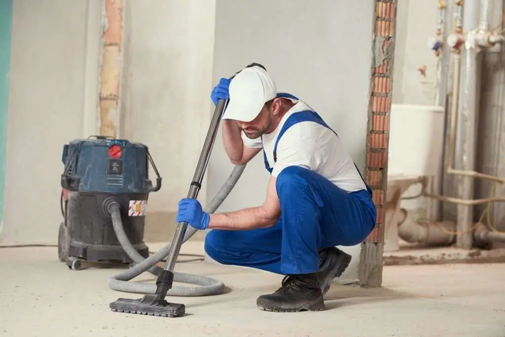 un homme entrain de travailler dans chantier avec un aspirateur eau et poussier